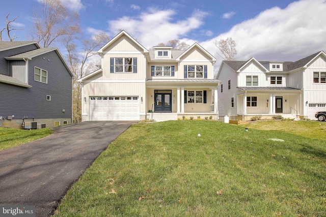 view of front of property with covered porch, central AC, a garage, and a front lawn