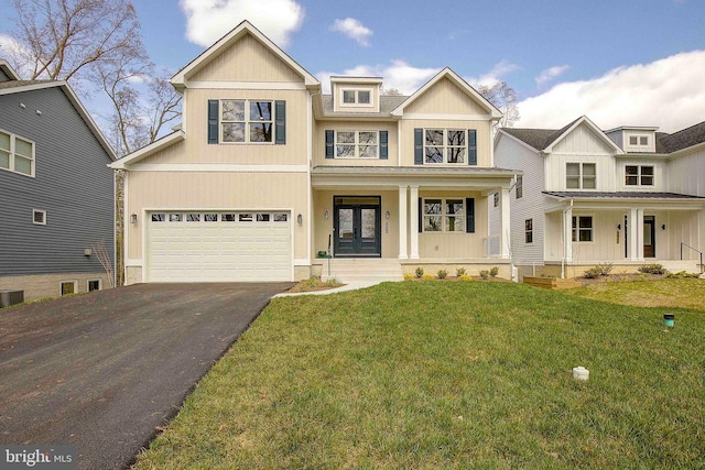 view of front of house with french doors, cooling unit, a front lawn, covered porch, and a garage