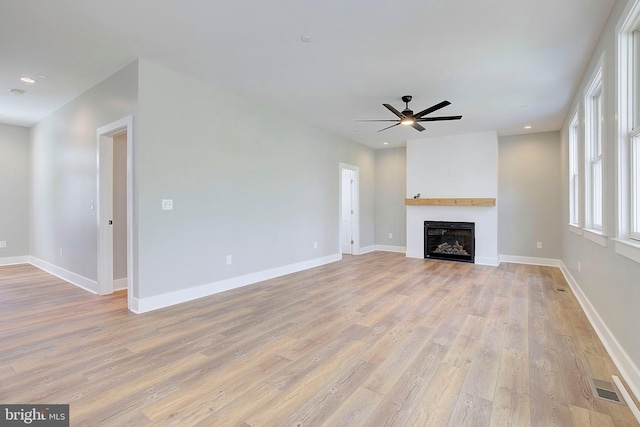 unfurnished living room featuring ceiling fan and light hardwood / wood-style floors