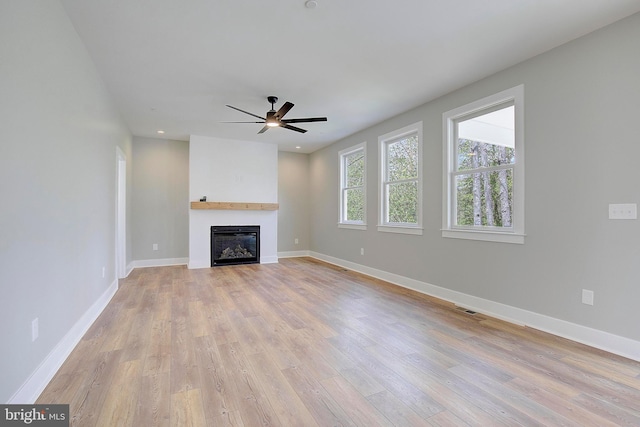 unfurnished living room with light hardwood / wood-style flooring and ceiling fan