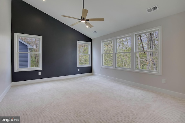 empty room with light carpet, vaulted ceiling, a wealth of natural light, and ceiling fan