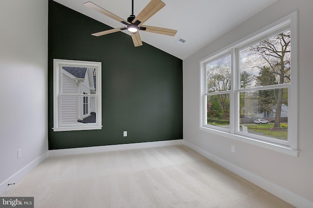 empty room featuring carpet flooring, a wealth of natural light, and vaulted ceiling