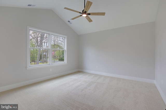 empty room featuring ceiling fan, light colored carpet, and vaulted ceiling