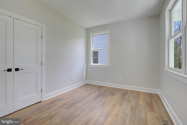 unfurnished bedroom featuring a closet and light hardwood / wood-style floors