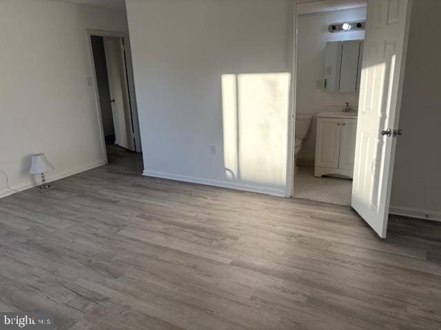 unfurnished room with sink and light hardwood / wood-style flooring