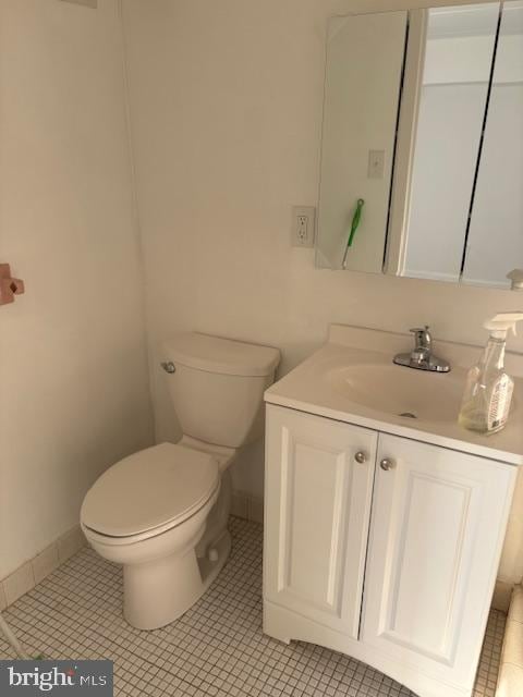 bathroom featuring toilet, vanity, and tile patterned flooring