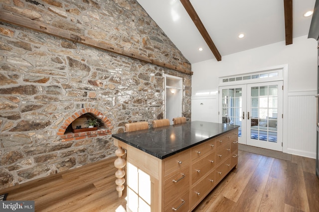 kitchen with wood-type flooring, french doors, a center island, beamed ceiling, and high vaulted ceiling