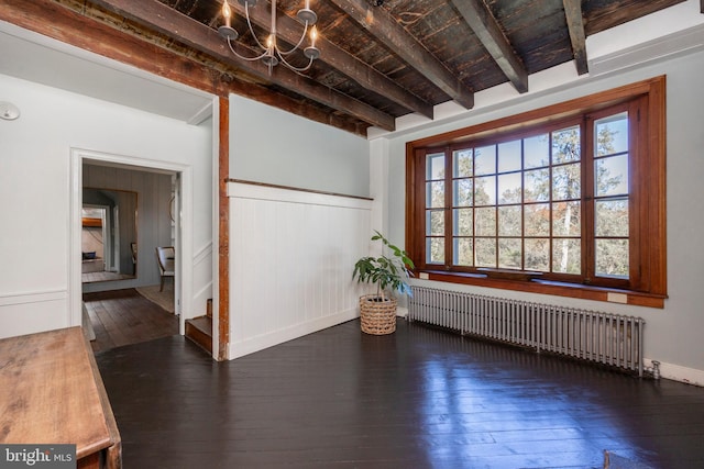 empty room featuring radiator heating unit, beamed ceiling, and dark hardwood / wood-style flooring