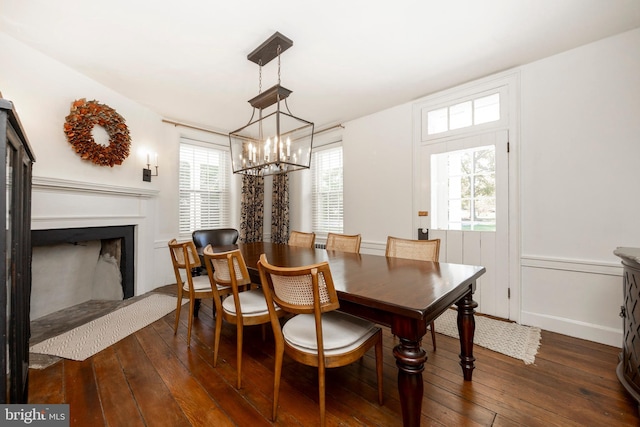 dining room with a healthy amount of sunlight, a chandelier, and dark hardwood / wood-style floors