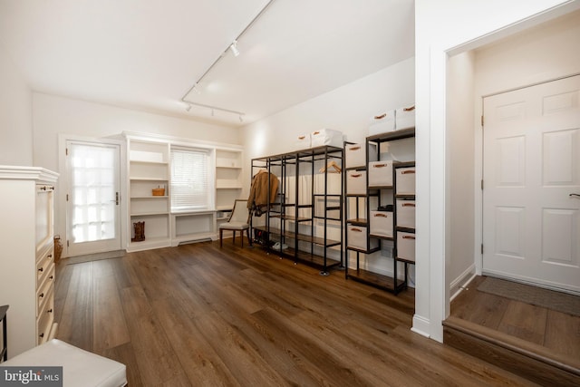 miscellaneous room with rail lighting and dark hardwood / wood-style flooring