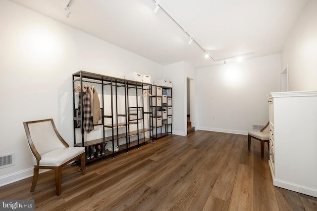 living area with dark wood-type flooring and rail lighting