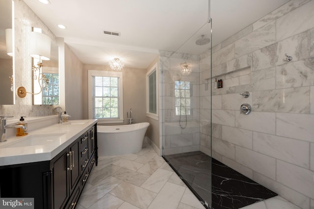 bathroom featuring vanity, an inviting chandelier, and separate shower and tub