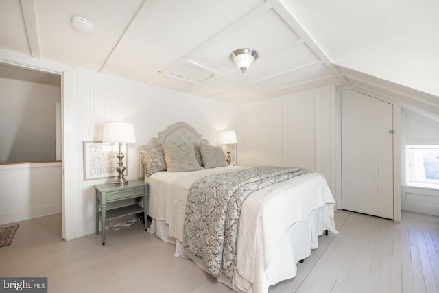 bedroom featuring light hardwood / wood-style floors and lofted ceiling