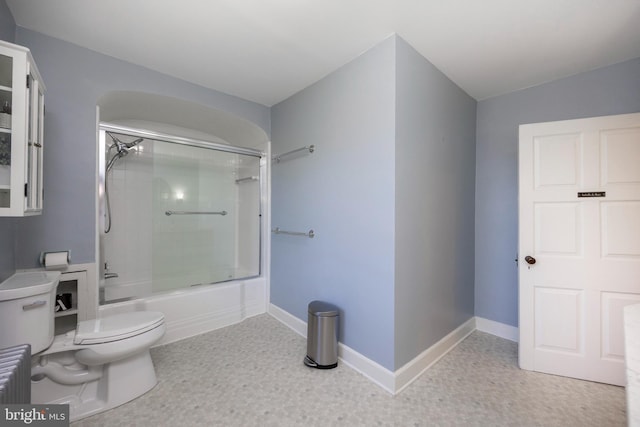 bathroom featuring toilet and combined bath / shower with glass door