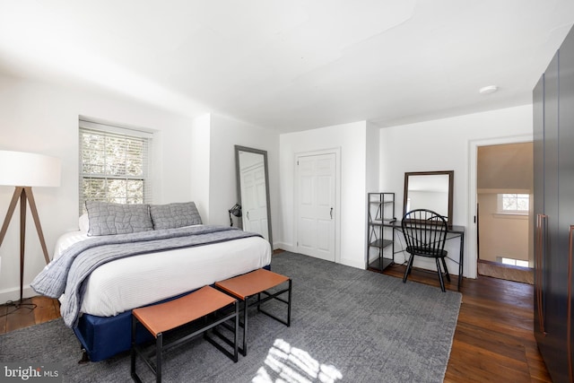 bedroom featuring multiple windows and dark hardwood / wood-style flooring