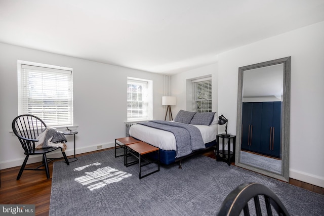 bedroom with dark hardwood / wood-style floors