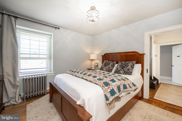 bedroom featuring light wood-type flooring and radiator