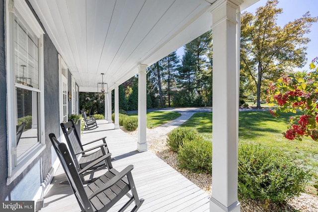 wooden deck featuring a porch and a yard