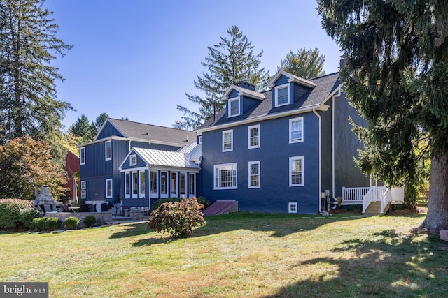 rear view of property with a lawn