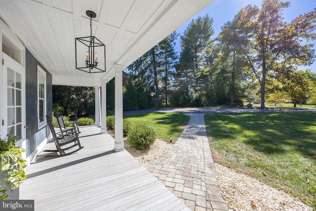 wooden deck featuring a yard and covered porch