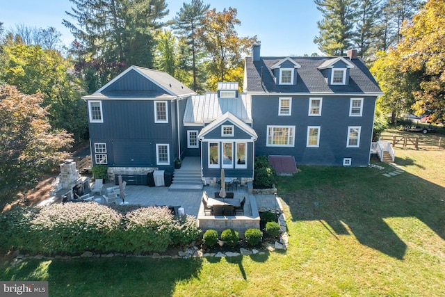 rear view of property featuring a patio area, a lawn, and an outdoor living space