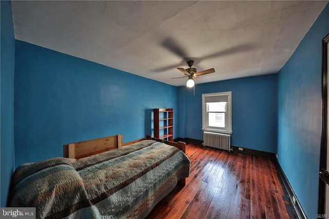 bedroom with ceiling fan, radiator heating unit, and dark hardwood / wood-style flooring