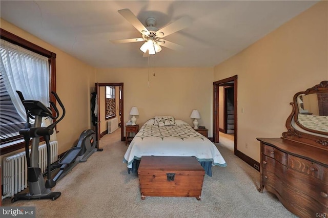 bedroom featuring light carpet, radiator heating unit, and ceiling fan