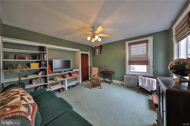 carpeted living room featuring a wealth of natural light, radiator, and ceiling fan