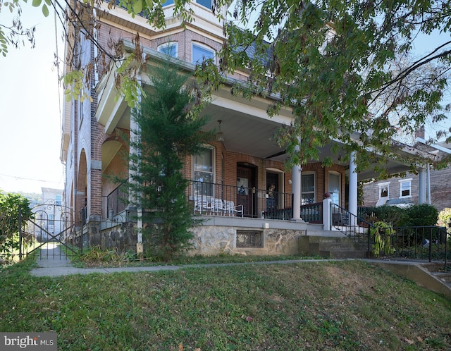 view of front of home with covered porch and a front lawn