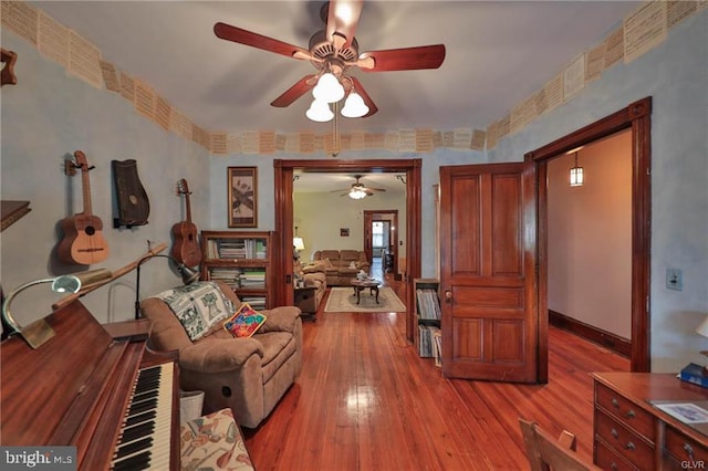 living room with light hardwood / wood-style floors and ceiling fan