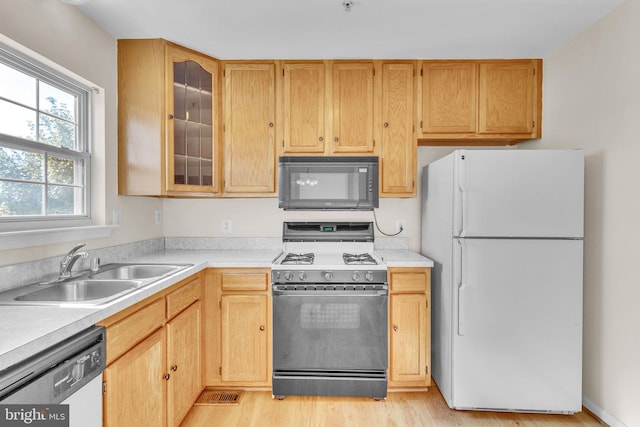 kitchen featuring light brown cabinets, light hardwood / wood-style flooring, sink, and white appliances