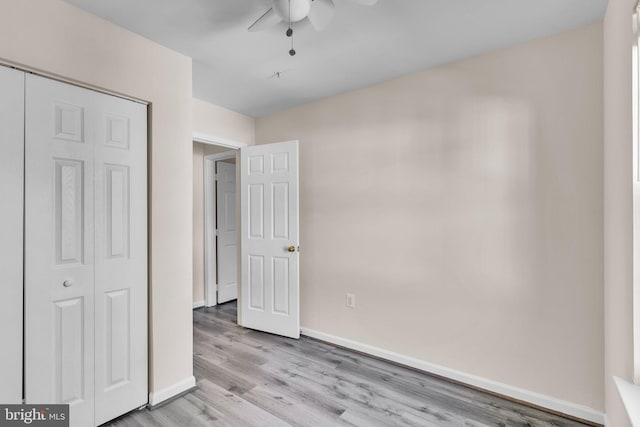 unfurnished bedroom featuring a closet, light hardwood / wood-style floors, and ceiling fan