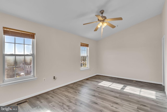 unfurnished room with a wealth of natural light, light hardwood / wood-style flooring, and ceiling fan