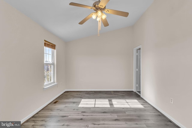 empty room featuring ceiling fan, lofted ceiling, and light wood-type flooring