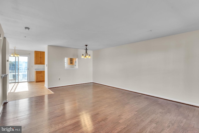 unfurnished room with light hardwood / wood-style flooring and a chandelier