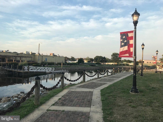 surrounding community featuring a lawn and a water view