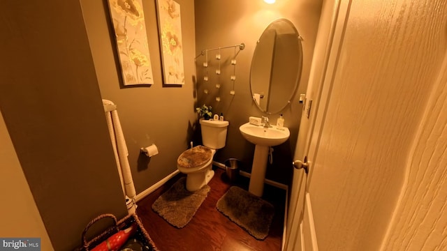 bathroom featuring toilet and wood-type flooring