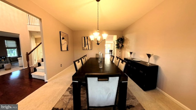 dining room featuring vaulted ceiling, dark hardwood / wood-style floors, and an inviting chandelier