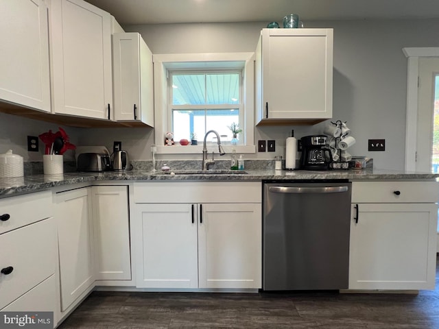 kitchen with dark stone counters, sink, stainless steel dishwasher, white cabinetry, and dark hardwood / wood-style flooring