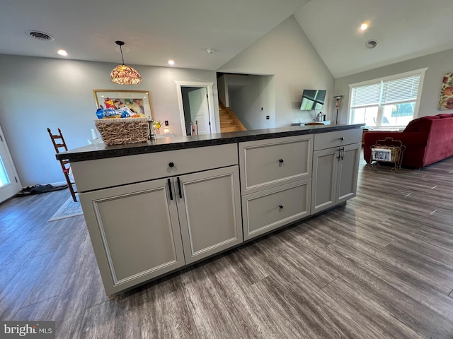 kitchen featuring lofted ceiling, hanging light fixtures, dark wood-type flooring, and a kitchen island