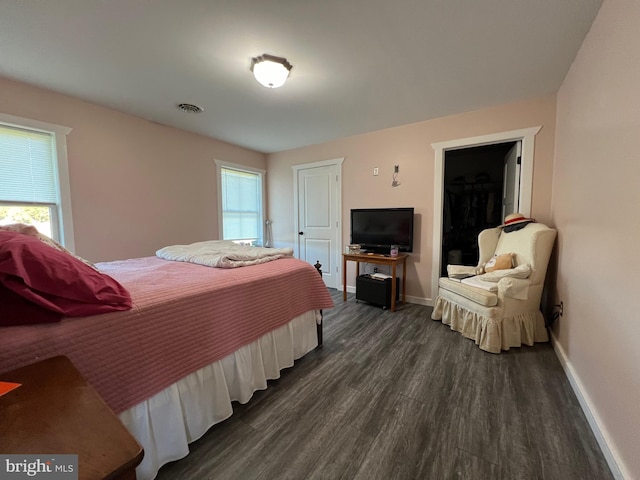 bedroom with dark hardwood / wood-style floors and a closet