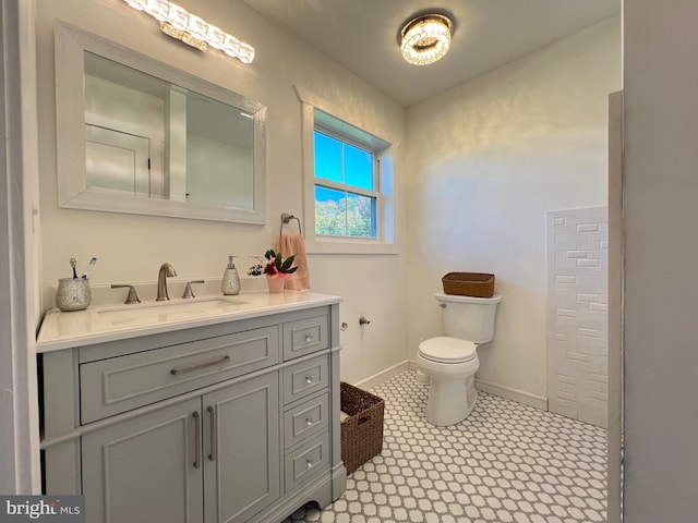 bathroom with toilet, vanity, and tile patterned floors