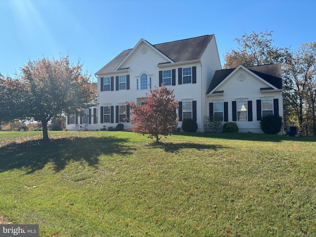 colonial home with a front yard and central AC unit