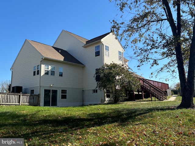 rear view of property with a lawn and a wooden deck