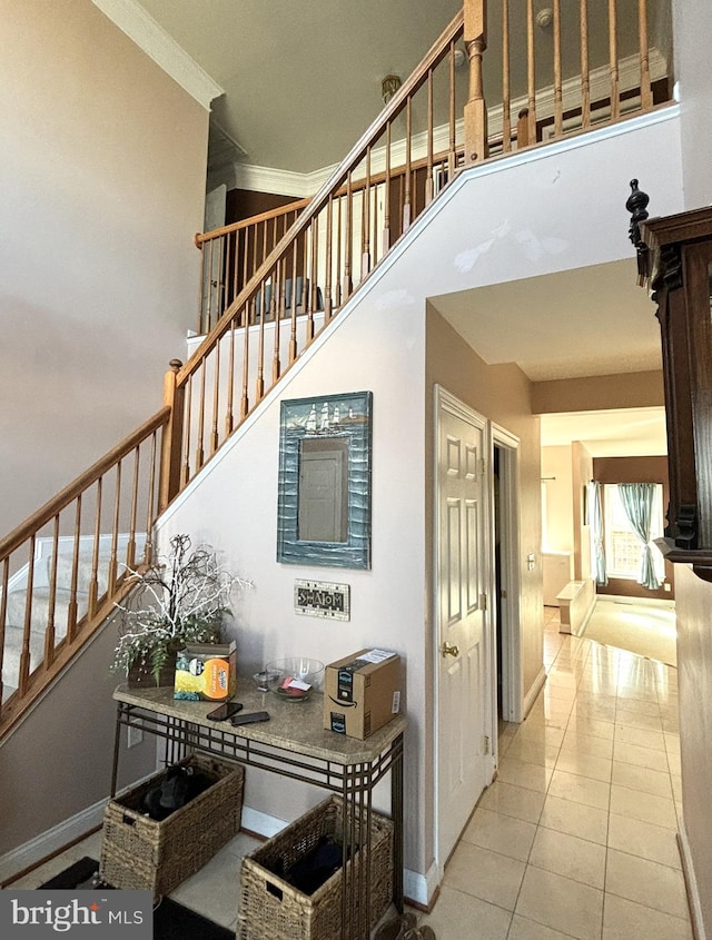 staircase with tile patterned flooring and ornamental molding