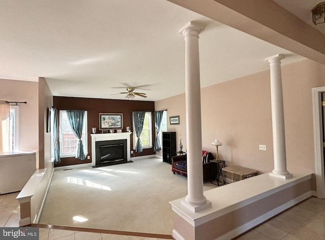 unfurnished living room with decorative columns, light carpet, plenty of natural light, and ceiling fan