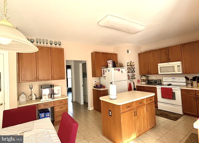 kitchen with decorative light fixtures, a kitchen island, white appliances, and light tile patterned floors