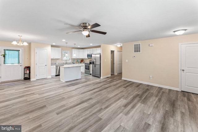 kitchen with light hardwood / wood-style floors, appliances with stainless steel finishes, plenty of natural light, and white cabinets