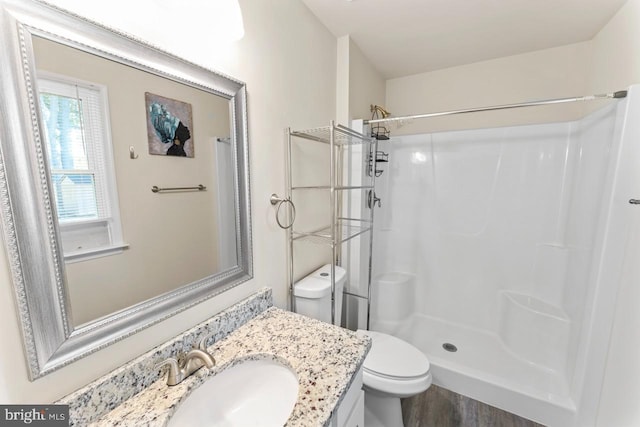 bathroom with vanity, toilet, a shower, and hardwood / wood-style floors