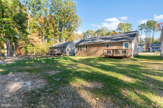 rear view of house with a wooden deck and a lawn